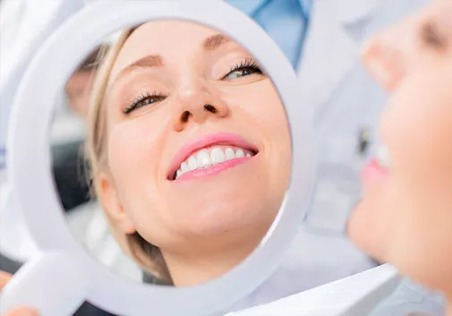 Woman admiring smile in mirror